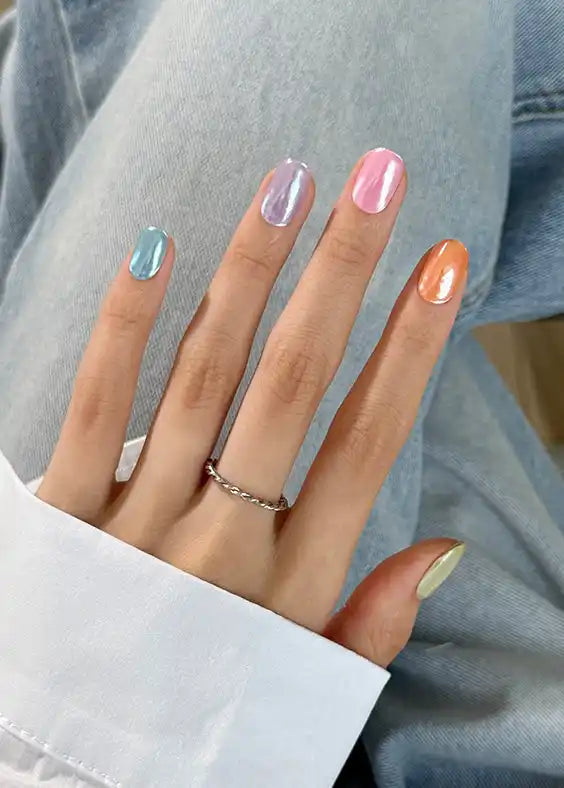 İris pastel gökkuşağı tırnaklara sahip el ve döndürülmüş gümüş yüzük