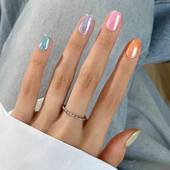 İris pastel gökkuşağı tırnaklara sahip el ve döndürülmüş gümüş yüzük