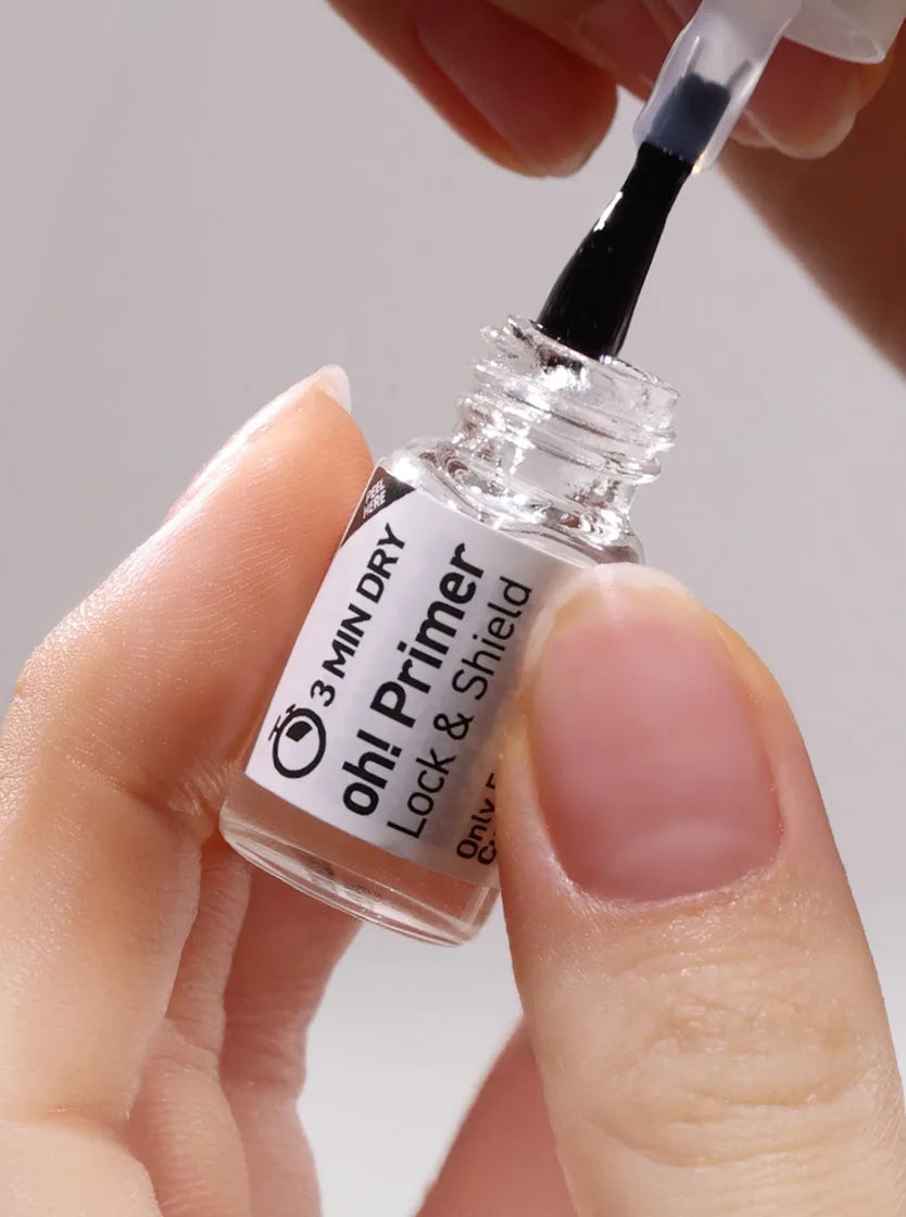 oh! Primer şişesi ve fırçası elde tutuluyor